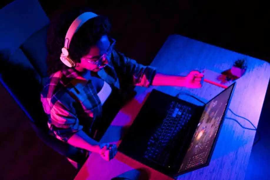 Person gaming on laptop with headphones